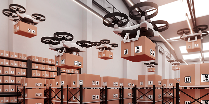 A group of drones carrying boxes in a warehouse.