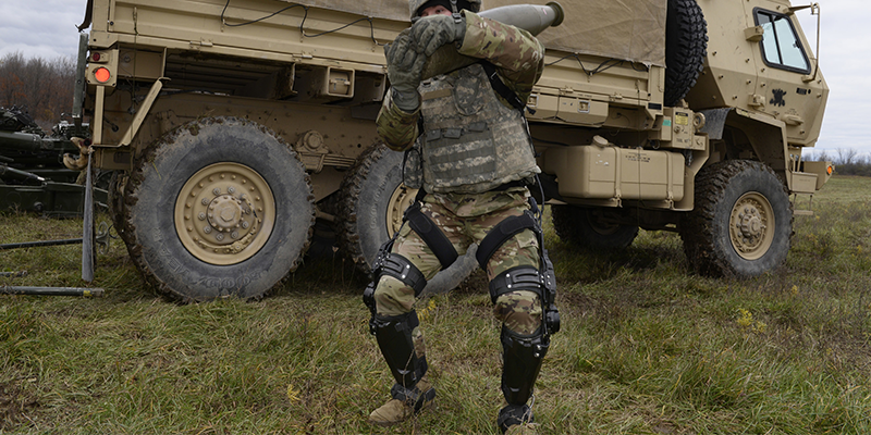 A solider wearing the Onyx exoskeleton on their lower limbs to help carry a heavy load.